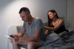 Couple in bed experiencing the emotional distance caused by porn addiction and its impact on relationships.