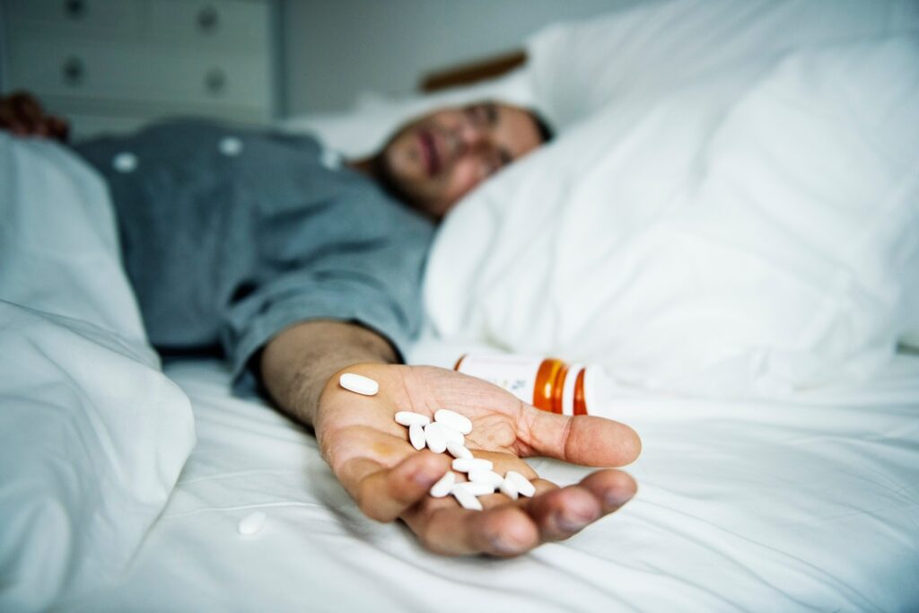 Man struggling with dopamine addiction, holding pills as part of addiction recovery and therapy