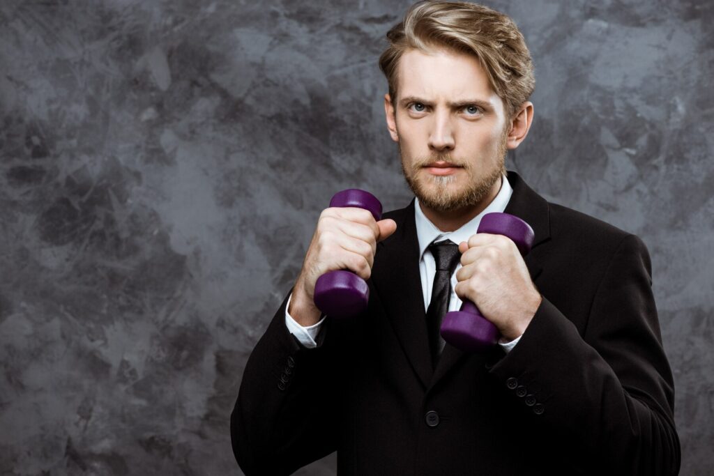 Man exercising with dumbbells, highlighting the importance of physical health and fitness in improving mental well-being for men.
